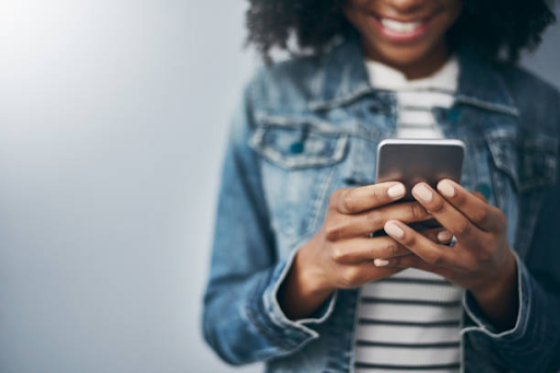 Person smiling while using a smartphone, representing user-friendly interface design in action.